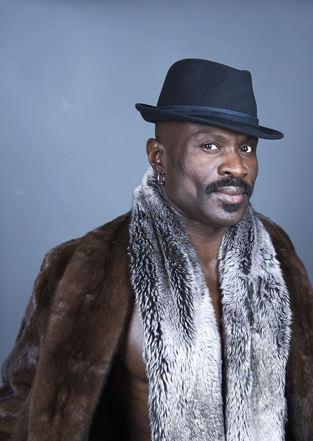 Man wearing hat, (faux) fur coat and scarf. Photo by Alina Oswald.