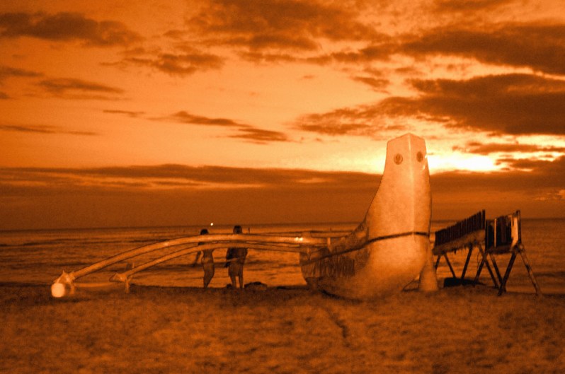 Couple watching the sunset on Waikiki Beach, Honolulu, Hawaii. Photo by Alina Oswald.