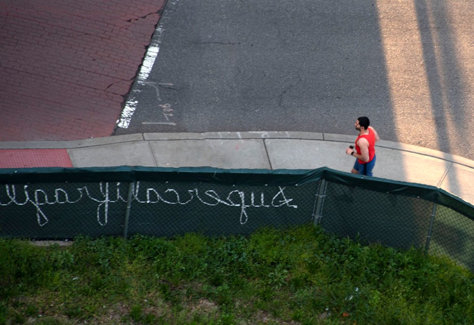 Covid-19 life: Running without mask along supercalifragilisticexpialidocious sign. ©Alina Oswald.