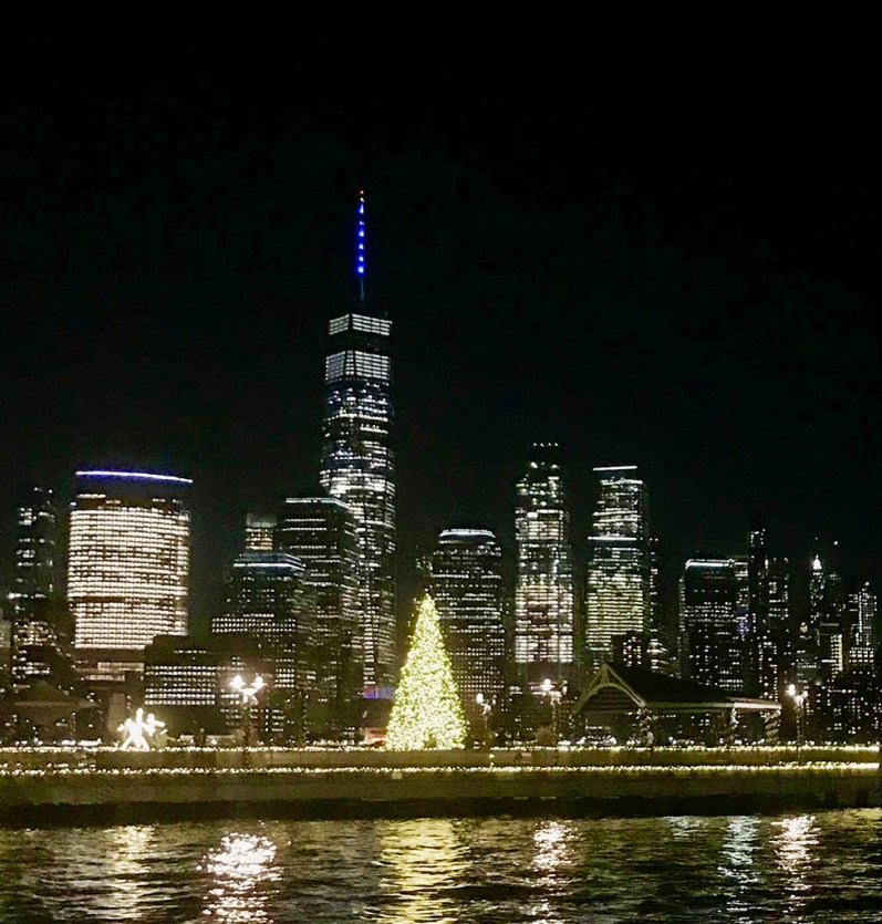 Christmas tree lights on Jersey City pier at night. In the background, Freedom Tower and Lower Manhattan. ©Alina Oswald. All Rights Reserved.
