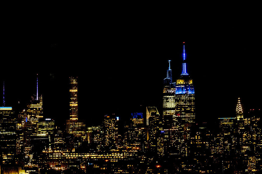 Midtown Manhattan at night in blue and yellow, the colors of the Ukrainian flag.